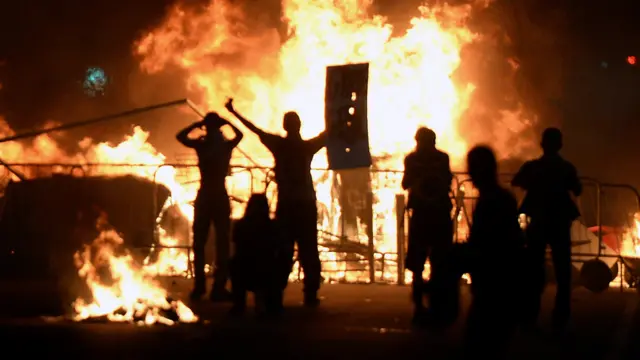 ريو دي جانيرو - متظاهرون يهتفون وخلفهم نار أضرموها احتجاجا على الفساد وارتفاع الأسعار. (أ.ف.ب.)