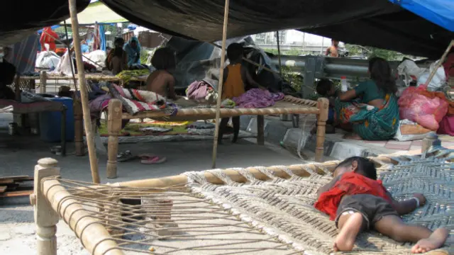 तिरपाल के नीचे रह रहे लोग 