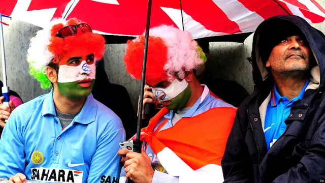 बर्मिंघम में हुई बारिश ने मैच देखने आए दर्शकों को अपने छातों में सिमटने को मजबूर कर दिया. बारिश की वजह से अगर मैच नहीं हो पाया तो ट्रॉफ़ी दोनों टीमों को संयुक्त रूप से दे दी जाएगी. (फ़ोटो: पीए)