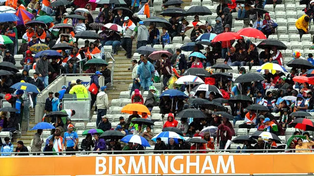 बारिश बर्मिंघम में दर्शकों के उत्साह पर पानी नहीं फेर पाई. तस्वीर गवाह है कि छाते लगाकर भी लोग मैच का आनंद लेने के लिए मौजूद थे. (फ़ोटो: एएफ़पी)