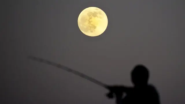 امریکی شہر کیلیفورنیا میں لٹل راک میں ایک شخص سپر مون کی روشنی میں مچھلی کا شکار کر رہا ہے۔