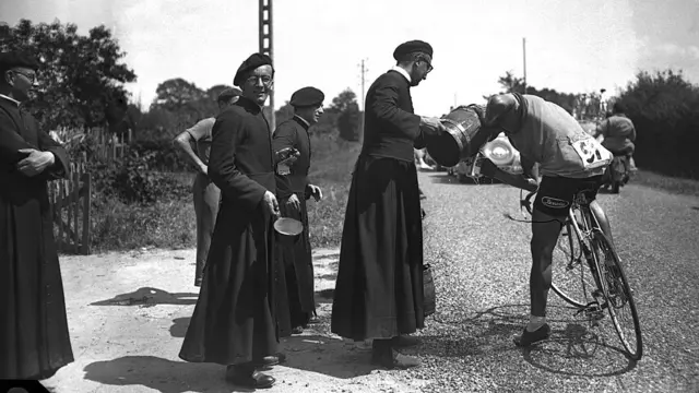 El italiano Alberto Ghirardi bebe de un balde ofrecido por un cura, tras recargar su botella de agua durante la 7° etapa del Tour de 1950.