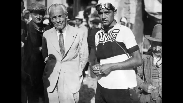 El creador del Tour de Francia, Henri Desgrange (izq.), posa sonriente el 17 julio de 1932 junto al ciclista italiano Amerigo Caccioni antes del inicio de la 8° etapa, Montpellier-Marsella.