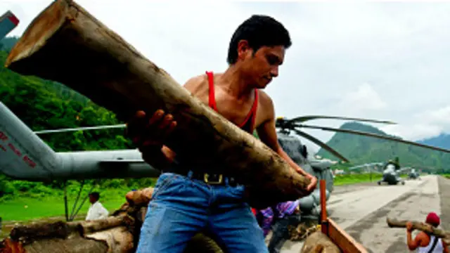 अंतिम संस्कार के लिए हेलीकॉप्टर में लकड़ी लादते लोग