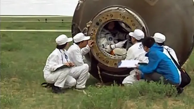 الفنيون يتحدثون إلى الرائد ني هايشينغ قبل خروجه من المركبة.