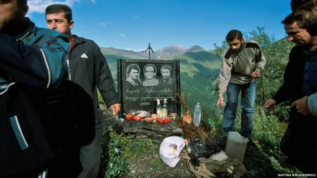 2000-ci ildə yol qəzasında həlak olmuş 3 adamın xatirə lövhəsi yanında duran sürücülər. Justyna Mielnikiewicz 