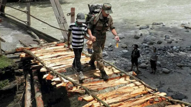 अस्थाई पुल के ज़रिए एक बच्चे को सुरक्षित निकाला जा रहा है. 