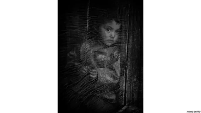 तुर्तुक गांव में अपने घर से निहारती आंखें. ये उन चंद गांवों में से है जहां पर्यटकों का आना जाना मुमकिन है.