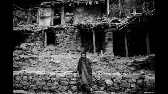 Hombre parado frente a una casa destruida por un derrumbe