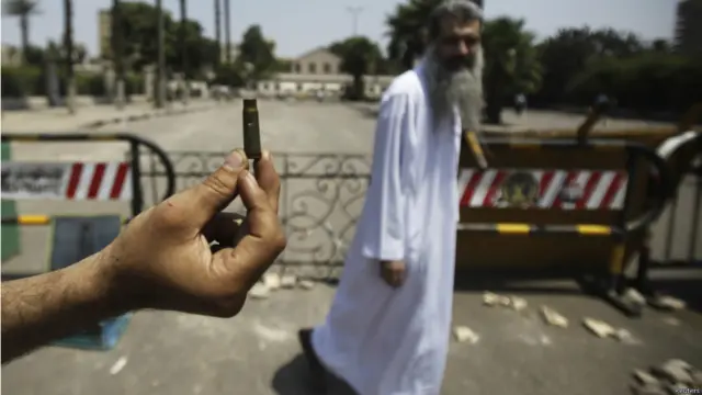 یکی از طرفداران رییس جمهور مصر پوکه گلوله ای را که از سوی مخالفان شلیک شده بود به خبرنگاران نشان می دهد