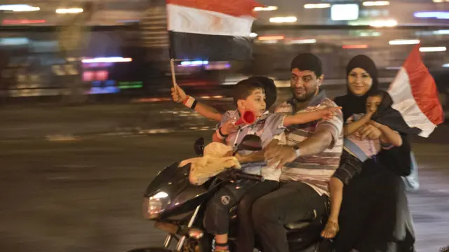 Familia celebrando arriba de una moto, AFP
