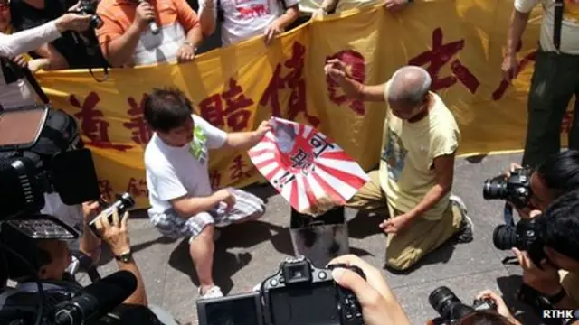 香港保钓人士在日本驻香港总领事馆所在大楼外焚烧日本军旗（香港电台图片6/7/2013）