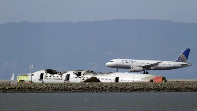 Pesawat United Airlanes mendarat di dekat bangkai pesawat Asiana
