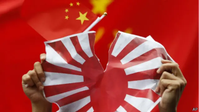 手持中國國旗的香港抗議者撕毀紙製的日本海軍旗