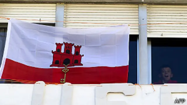 Niño al lado de una bandera gibraltareña