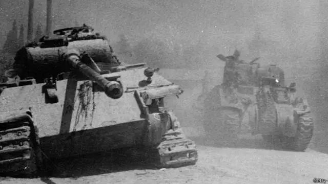 Un tanque alemán Panther abandonado en el camino que recorre un tanque Sherman de los aliados, en Italia, 1944.