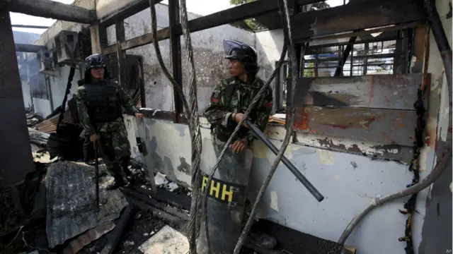 Tentara berjaga-jaga di ruangan lapas yang terbakar, foto oleh Binsar Bakkara, AP