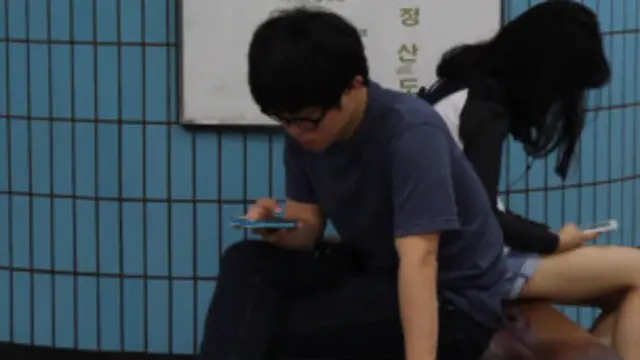 Adolescente coreano usando celular no metrô. Foto: reproduçãosegredo apostas esportivasvídeo