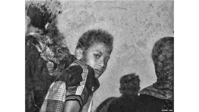 राहत शिविर के खाना परोसे जाने वाले क्षेत्र में एक बच्चा. खाना राहत शिविर में रह रहे लोग खुद ही बनाते हैं.