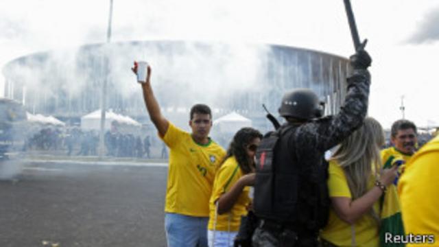 Torcedores tentam escapar de gás lacrimogêneo diante do estádio Mané Garrincha, em Brasília | Foto: Reuters