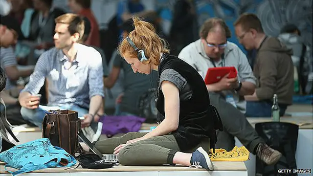 periodistas trabajan sentados en el pavimento