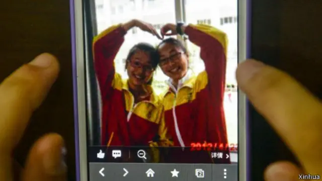 浙江江山中学师生以手机展示叶梦园（左）与王琳佳（右）的遗照（新华社图片8/7/2013）
