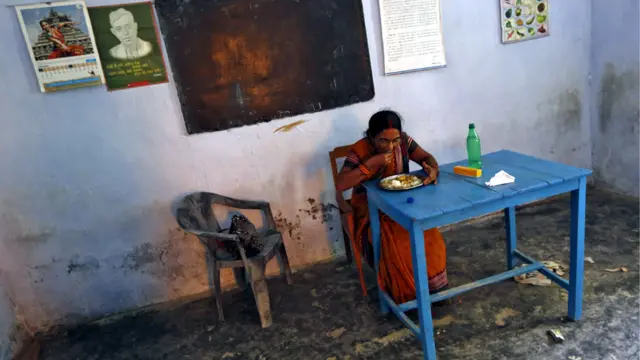 بيهار - مديرة المدرسة سريماتي كوماري تتذوق وجبة غداء قبل توزيعها على تلاميذ مدرستها. أثارت حادثة تسمم ووفاة 23 طفلا في الولاية غضبا شديدا في الهند. (صورة رويترز)