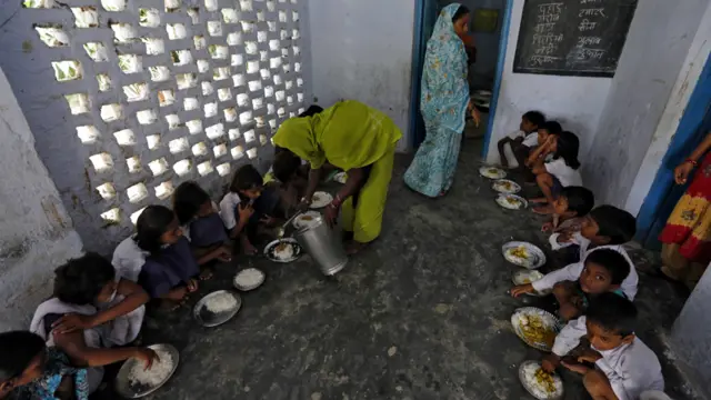 بيهار - طاهية في مدرسة براهيمبور الابتدائية وجبة الغداء المجانية على التلاميذ. يحظى برنامج التغذية المدرسية بدعم المنظمات غير الحكومية والامم المتحدة لأنه يشجع الأهل على ارسال الاطفال الى المدارس.