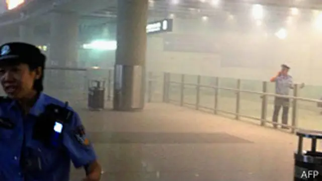 北京首都机场执勤警员在冀中星引爆自制炸弹后驱散人群（20/7/2013）