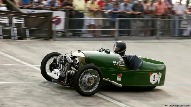 अपनी 1930 की मॉरगन तिपहिया गाड़ी में ज्यूरिख के ऑफ़ीन रेनबैन साइकलिंग ट्रैक से गुज़रते कुर्त कॉफ़मैन