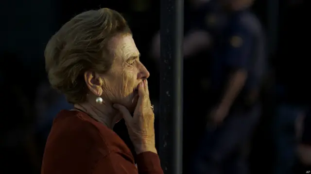 Mujer pariente de una de las víctimas del accidente de tren en Santiago de Compostela junto al centro de información para las familias de las víctimas. 