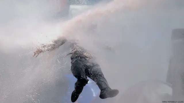 Bazı göstericiler üzerlerine sıkılan suya karşı koymaya çalıştı. 