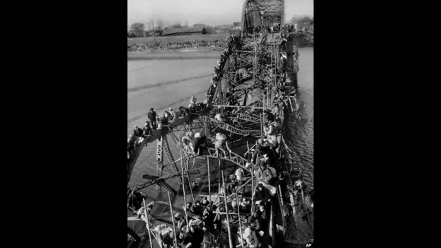 उत्तर कोरिया के प्योंगयांग के नागरिक और दूसरे इलाकों के शरणार्थी 4 दिसंबर 1950 को शहर के पुल को रेंग कर पार करते हुए. ये लोग चीनी कम्युनिस्ट सेनाओं के आक्रमण से बचने के लिए दक्षिण की ओर पलायन कर रहे हैं. एपी