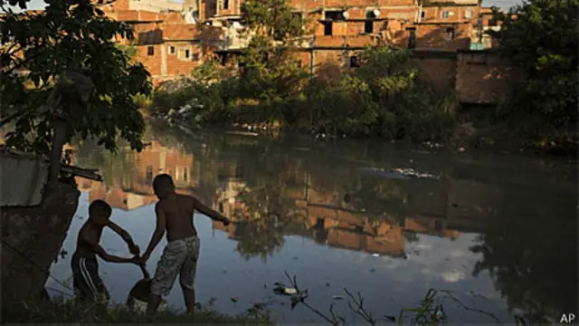 Crianças em um rio poluído no complexo de Manguinhos, Rio de Janeiro (AP)