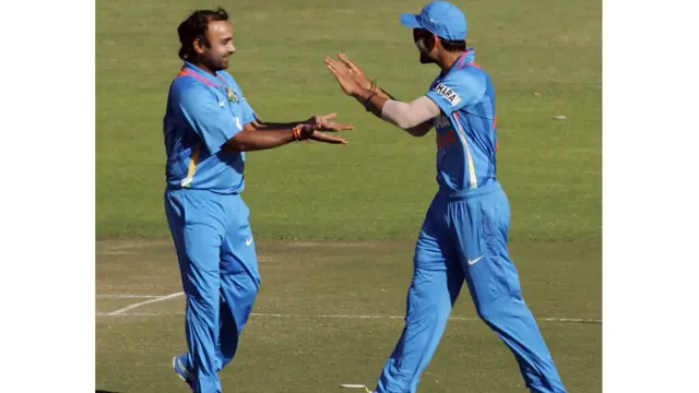 भारतीय गेंदबाज़ अमित मिश्रा ज़िम्बाब्वे के खिलाड़ी को आउट करने के बाद कप्तान विराट कोहली के साथ प्रसन्न मुद्रा में. 
