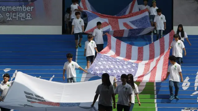韩国终战纪念仪式上学生举起参战国旗帜进场（27/7/2013）