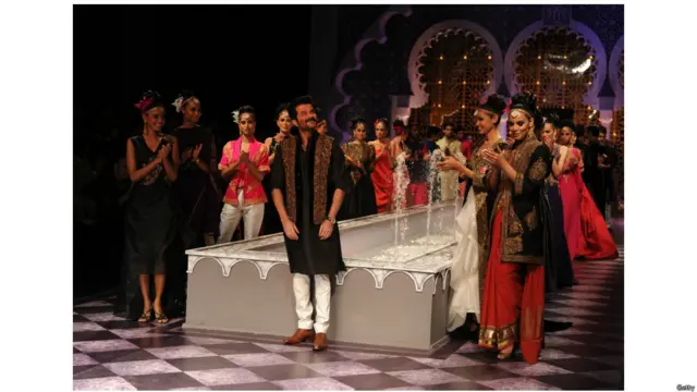  'इंडियन ब्राइडल फ़ैशन वीक 2013' में बॉलीवुड अभिनेता अनिल कपूर फैशन डिज़ाइनर राघवेंद्र राठौर के क्रिएशन को पेश करते हुए.