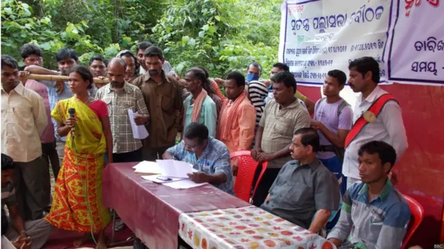 एक ग्रामसभा में अपनी बात रखती एक डोंगरिया कोंध महिला. कई ग्राम सभाओं ने ब्रितानी कंपनी वेदांत के प्रोजेक्ट को नकार दिया है. स्थानीय भाषा में डंगर का मतलब है पहाड़, डंगरिया उन्हें कहा जाता है जो पहाड़ों पर रहते हैं. आदिवासियों की यह जाति दक्षिणी ओडिशा के दो जिलों, रायगढ़ा और कलाहांड़ी में पाई जाती है.राज्य में 60 से अधिक आदिवासी जातियां निवास करती हैं. इनमें 22 प्रिमिटिव ट्राइब हैं. डोंगरिया कोंध इनमें से एक हैं. डोंगरिया के अलावा कुटिया आदिवासी भी वेदांत के प्रोजेक्ट से प्रभावित हो रहे हैं.