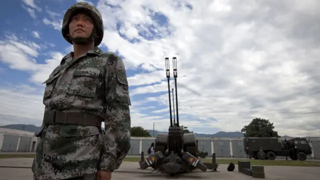 一名解放军士兵在PG99双管35毫米防空炮前摆姿势。