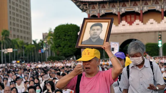 老翁手持亲属遗照