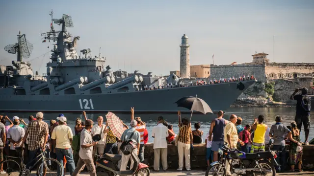 Un grupo de personas mira la llegada de los barcos