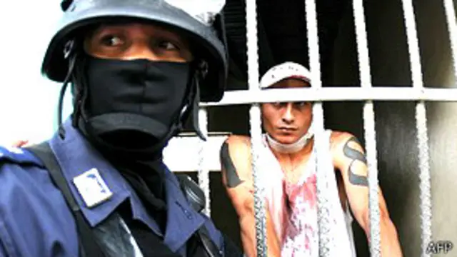 Policía custodiando un preso herido tras el motín del fin de semana en la Penitenciaria Nacional, la mayor cárcel del país