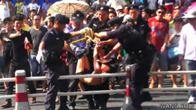 杭州试图砍人男子被警察抬走（网友王禹力提供图片10/8/2013）