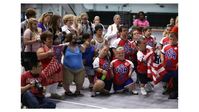 मिशिगन के ईस्ट लैन्सिंग में हुई 2013 वर्ल्ड ड्वार्फ़ गेम्स में वॉलीबॉल मेडल समारोह के बाद तस्वीरें खिंचाते खिलाड़ियों के परिजन और समर्थक.