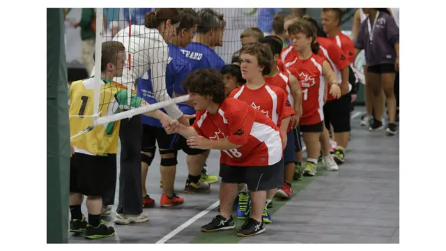 कनाडा की वॉलीबॉल टीम के सदस्य यूरोपीयन वॉलीबॉल टीम के खिलाड़ियों से हाथ मिलाते हुए.