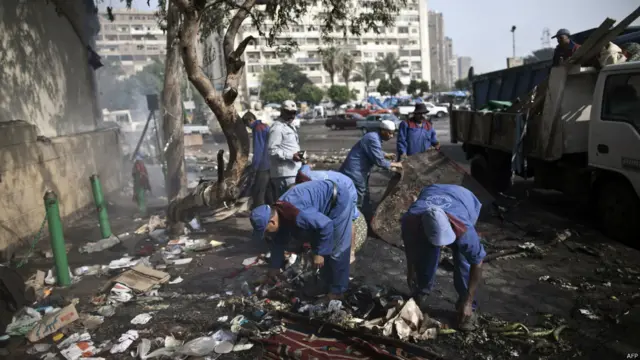 Petugas kebersihan di lapangan al-Adawiya, foto oleh Mahmoud Khaled/AFP