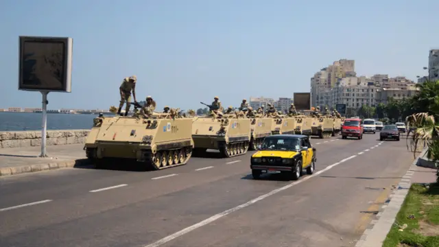 جمعے کے روز مصر بھر میں سکیورٹی کے سخت انتظامات کیے گئے تھے۔ اس تصویر میں ساحلی شہر سکندریہ کی سڑکوں پر بکتر بند گاڑیاں گزر رہی ہیں۔ 