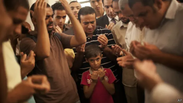 Egípcios em funeral de homem morto em confrontos no sábado, no Cairo (AP)