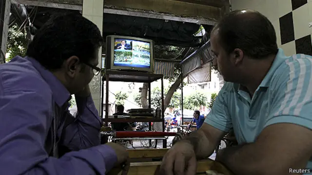 egipcis ven las noticias en un café de El Cairo