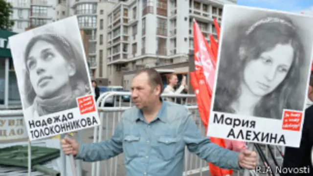 Участник оппозиционного митинга в Москве 12.06.2013 держит портреты участниц группы Pussy Riot Марии Алехиной и Надежды Толоконниковой